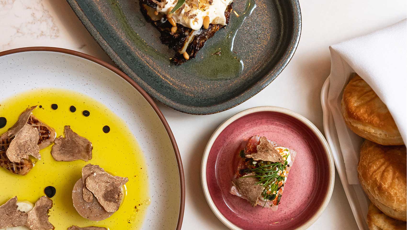 Chef-crafted tasting plates with truffle accents and fresh baked rolls