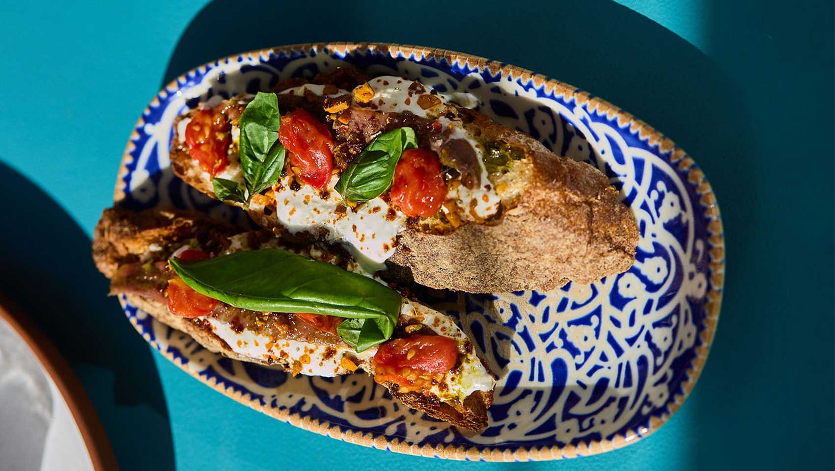 Italian-style crostini topped with creamy cheese, tomatoes, basil, and herbs