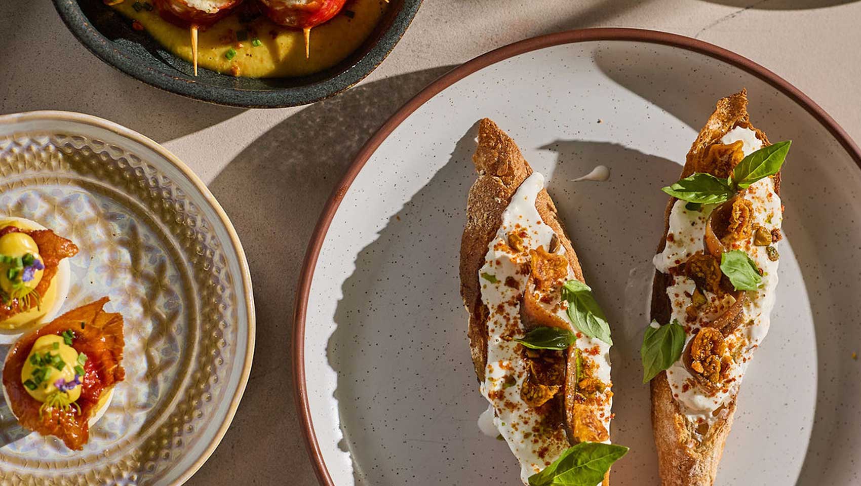 House-made crostini topped with creamy cheese, herbs, and seasonal garnishes