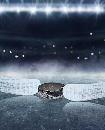 two hockey sticks with puck on ice