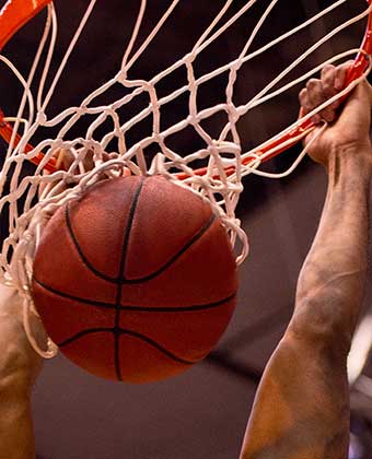 arms hanging onto a basket post-dunk